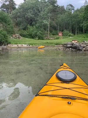 a yellow kayak in the water next to a river at Villa Hagavik, studio apartment Peter