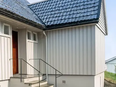 a house with a metal roof and stairs at Apartment Samlen Vasselgård by Interhome in Herand
