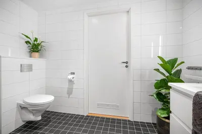 a white bathroom with a toilet and a sink at Modern apartment by the sea - Free parking in Bergen