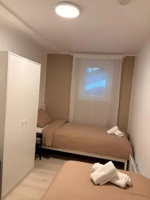 a small room with two beds and a window at Kirkevegen apartment in Brumunddalen