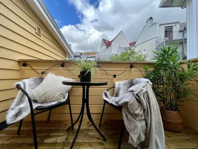 a small balcony with a table and two chairs at Exclusive apartment in historical house, Bergen in Bergen