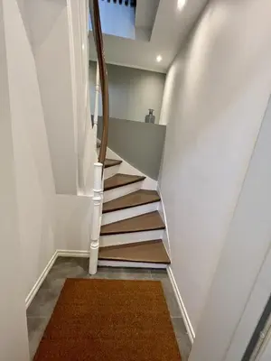 a stairwell with white walls and white stairs with a rug at Exclusive top apartment, central location in Bergen in Bergen