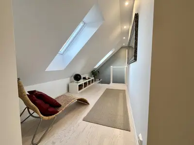 a white hallway with a chair and a skylight at Exclusive top apartment, central location in Bergen in Bergen