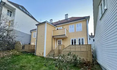 a wooden house with a fence in the yard at Eksklusiv leilighet sentralt i Bergen in Bergen
