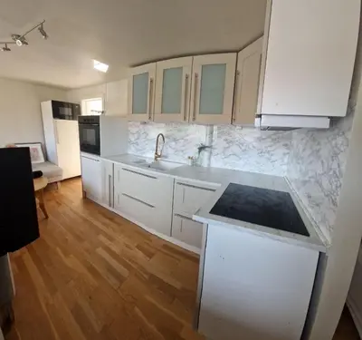 a kitchen with white cabinets and a counter top at Modern condominium in Bergen
