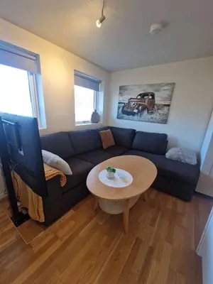 a living room with a blue couch and a table at Modern condominium in Bergen
