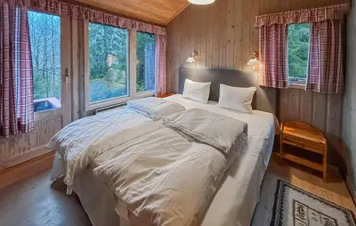 a bedroom with a large bed in a room with windows at 4 Bedroom Nice Home In Trysil in Trysil