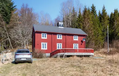 a red barn with a car parked in front of it at 2 Bedroom Stunning Home In Bjugn in Moen