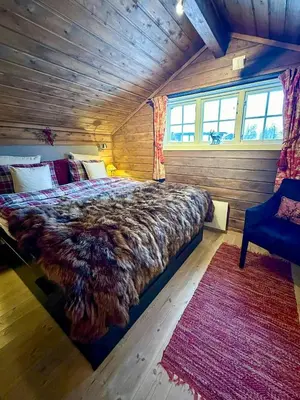 a bedroom with a large bed in a wooden room at Lovely Family Cabin Near Ski Stadium In Beitostølen in Beitostøl