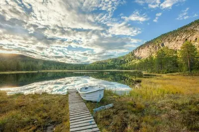 a boat sitting on the shore of a lake at Cabin At The Foot Of Andersnatten in Engar