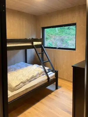 a bunk bed in a room with a window at Lovely Cabin With Hot Tub Near Syningtoppen in Torpo