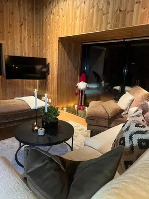 a living room with a couch and a table with candles at Charming and modern ski-in ski-out cottage in Hemsedal