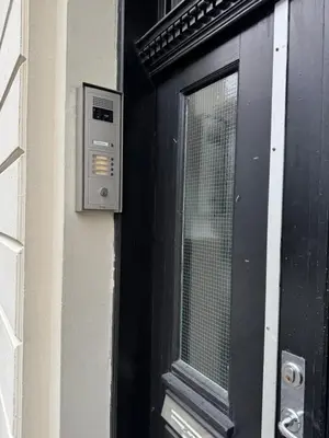 a black door with a window next to a building at Koselig sentrumsleilighet - Nær Bryggen in Bergen