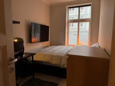 a small bedroom with a bed and a window at Koselig sentrumsleilighet - Nær Bryggen in Bergen