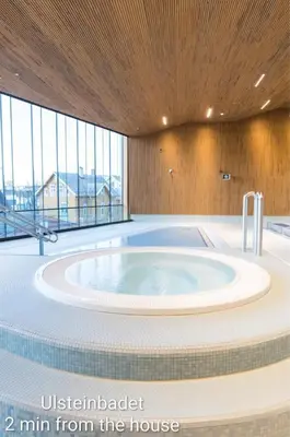 a hot tub in the middle of a room with windows at Lundenhuset 1917 - historic house in the heart of Ulsteinvik in Ulstein