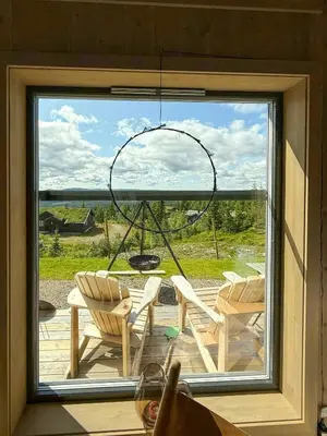 a window with a view of a patio with chairs at Modern Cabin With Ski-Inout Near Birken Trails in Rena