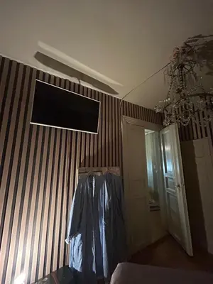 a room with a television on a striped wall at Central, charming, 1800s apartment in Lii