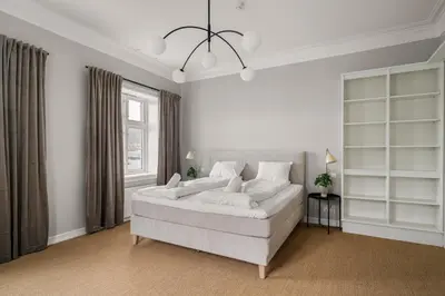 a white bedroom with a large bed and a window at Elegant Historic Villa - Stunning Views in Bergen