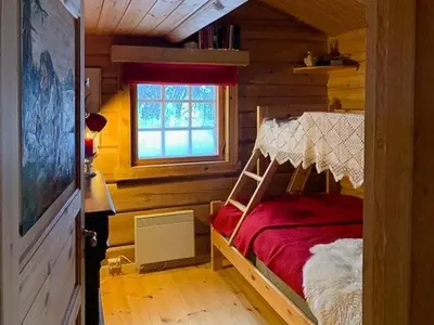 a bedroom with a bed in a log cabin at Enjoy Days In Traditional Log Cabin in Uvdal