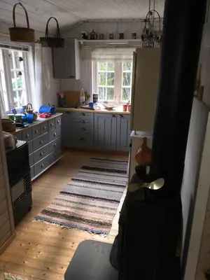 a kitchen with a refrigerator and a kitchen floor at Øyungen 2 in Namsos