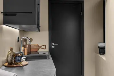 a kitchen with a black door next to a sink at Tromsø Apartment - in the heart of the city in Lii