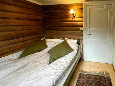 a bed in a room with a wooden wall at Timber Cabin With Ski-In Access At Solheisen in Hemsedal