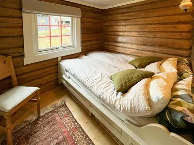 a bed in a wooden room with a window at Timber Cabin With Ski-In Access At Solheisen in Hemsedal