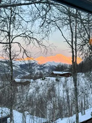 a view of a snow covered mountain with a train at Timber Cabin With Ski-In Access At Solheisen in Hemsedal