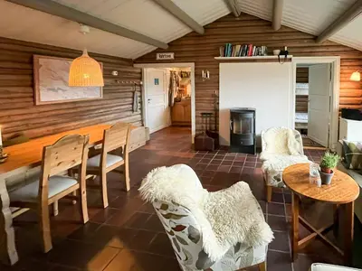 a living room with a table and chairs at Timber Cabin With Ski-In Access At Solheisen in Hemsedal