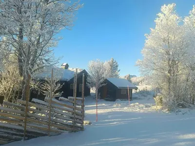 a cabin in the snow with a fence and trees at Log Cabin Near Muen And Myafallene in Venabygd