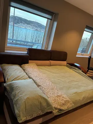 a bed in a room with a large window at Alesund apartment fantastic view in Ålesund