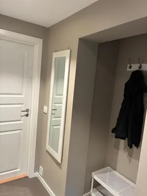 a bathroom with a mirror and a closet with a door at Alesund apartment fantastic view in Ålesund