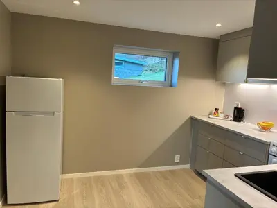 a kitchen with a white refrigerator and a window at Alesund apartment fantastic view in Ålesund