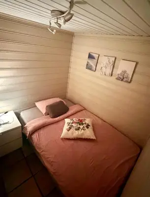 a small room with a bed with flowers on it at Cozy little apartment at the back of Bryggen in Bergen