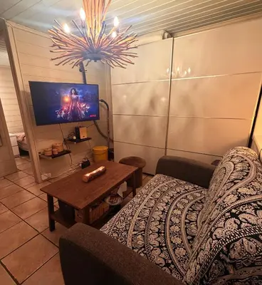 a living room with a couch and a tv at Cozy little apartment at the back of Bryggen in Bergen