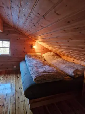 a log cabin with a bed in a room at Fjellvang in Haglebu