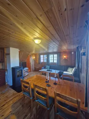 a living room with a wooden table and a couch at Fjellvang in Haglebu