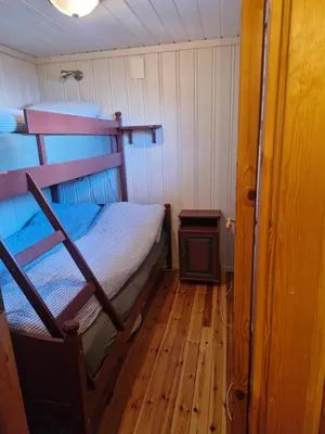 a bedroom with a bunk bed and a wood floor at Fjellvang in Haglebu