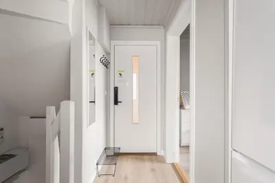 a white hallway with a chair in a room at Central Bergen - Stylish & Cozy in Bergen