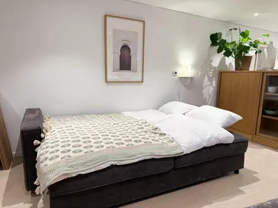 a bed in a bedroom with a picture on the wall at Soft Stay Apartment in Bergen