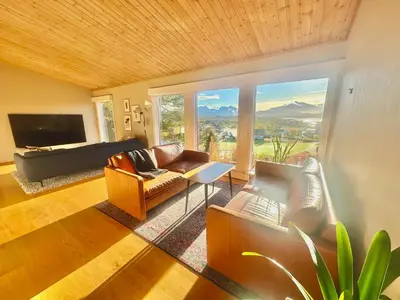 a living room with a couch and chairs and a television at Hilltop Panorama view retreat in Ålesund