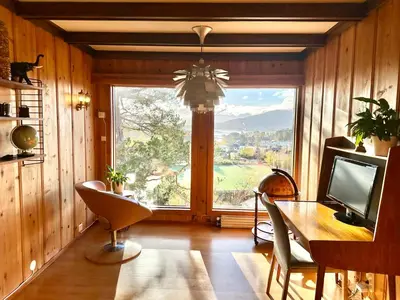 a dining room with a table and a large window at Hilltop Panorama view retreat in Ålesund