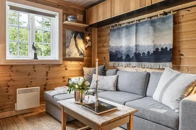 a living room with a couch and a table at Charming cabin in Hemsedal Golf Alpin - ideal for families, fishing & skiing in Hemsedal