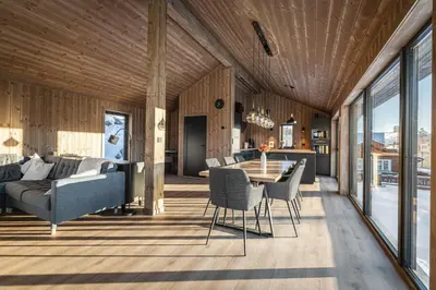 a living room with a table and a couch at New luxury cabin in Geilo with hot tub, mountain views & ski access in Geilo