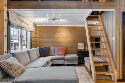 a living room with a couch and a loft bed at Vikinggrenda 16A by Vacation Trysil in Trysil