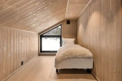 a bedroom with a bed in a room with a window at Trysil hytteomrade 2041 by Vacation Trysil in Hovi