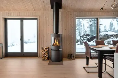 a fireplace in a living room with a table and chairs at Trysil hytteomrade 2041 by Vacation Trysil in Hovi