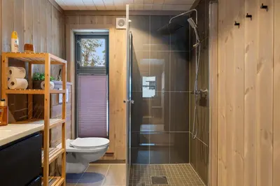 a bathroom with a toilet and a glass shower at Trysilfjell hytteomrade 2124 by Vacation Trysil in Hovi