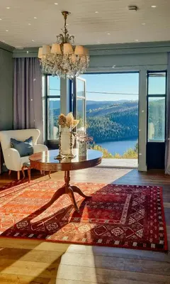 a living room with a table and a large window at Manor House With Panoramic Views Of Jotunheimen in Skammestein