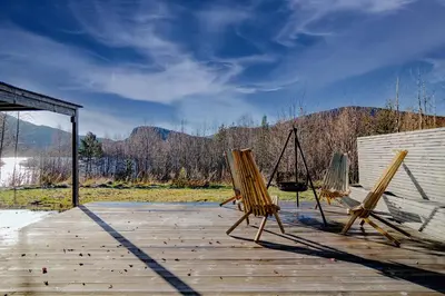 two chairs and a swing on a wooden deck at Unique Nature Hideaway Close to Norefjell